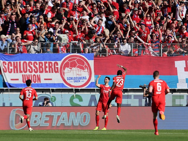Heidenheim's Tim Kleindienst celebrates scoring their second goal with teammates on April 6, 2024