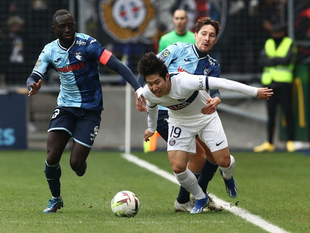 Paris Saint-Germain's Lee Kang-in in action with Le Havre's Arouna Sangante and Daler Kuzyayev on December 3, 2023