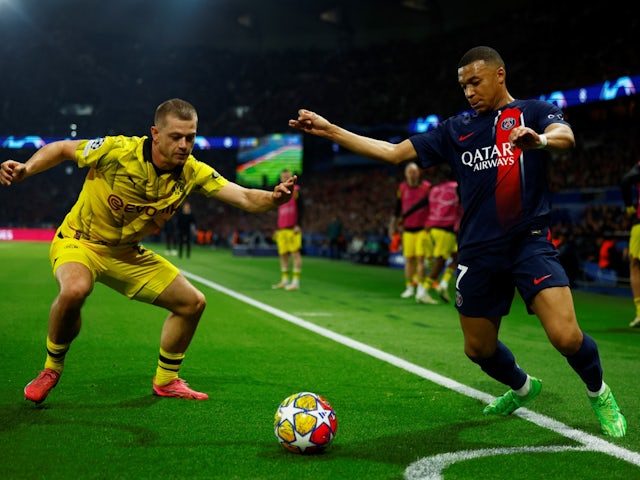 Borussia Dortmund's Julian Ryerson in action with Paris Saint-Germain's Kylian Mbappe on May 7, 2024