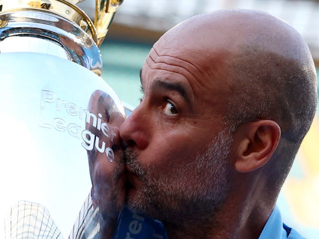 Manchester City manager Pep Guardiola celebrates with the trophy after winning the Premier League on May 19, 2024