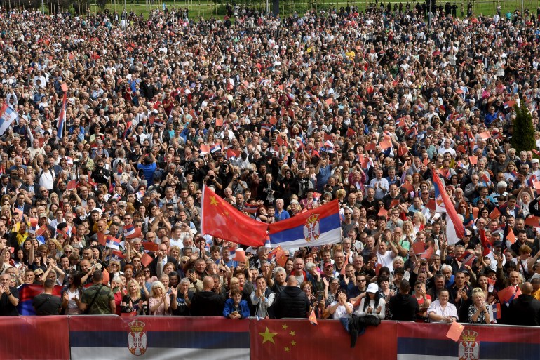 People waving Chinese and Serbian flags gather outside the Palace of Serbia during a welcome ceremony for Chinese President Xi Jinping in Belgrade. 