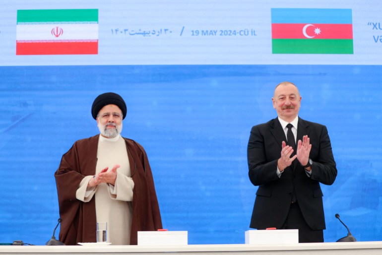 A handout picture provided by the Iranian presidency shows Iran's President Ebrahim Raisi (L) during a meeting with his Azeri counterpart Ilham Aliyev ahead of the inauguration ceremony of Qiz Qalasi, the third dam jointly built by Iran and Azerbaijan on the Aras River