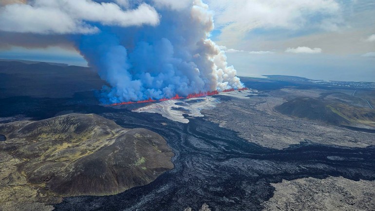 TOPSHOT - This handout picture released by the Icelandic Coast Guard on May 29, 2024 shows billowing smoke and flowing lava pouring out of a new fissure, during a surveilance flight above a new volcanic eruption on the outskirts of the evacuated town of Grindavik, western Iceland. A new volcanic eruption has begun on the Reykjanes peninsula in southwestern Iceland, the country's meteorological office said Wednesday, shortly after authorities evacuated the nearby town of Grindavik. (Photo by HANDOUT / Icelandic Coast Guard / AFP) / RESTRICTED TO EDITORIAL USE - MANDATORY CREDIT "AFP PHOTO /HANDOUT/ICELANDIC COAST GUARD " - NO MARKETING - NO ADVERTISING CAMPAIGNS - DISTRIBUTED AS A SERVICE TO CLIENTS