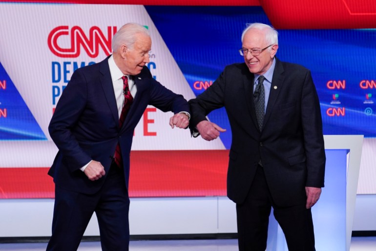 Joe Biden and Bernie Sanders rub elbows on stage at a CNN debate.