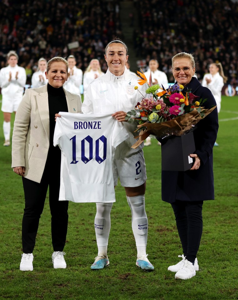 Lucy Bronze celebrating her 100th England appearance alongside Kay Cossington (left) and Sarina Wiegman on February 16, 2023