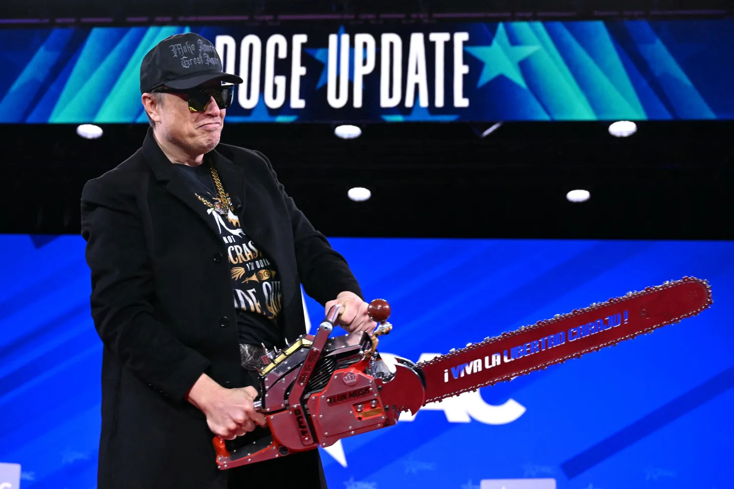 Elon Musk holds a chainsaw reading "Long live freedom, damn it" during the annual Conservative Political Action Conference (CPAC) at the Gaylord National Resort & Convention Center at National Harbor in Oxon Hill, Maryland, on Feb. 20, 2025. 
