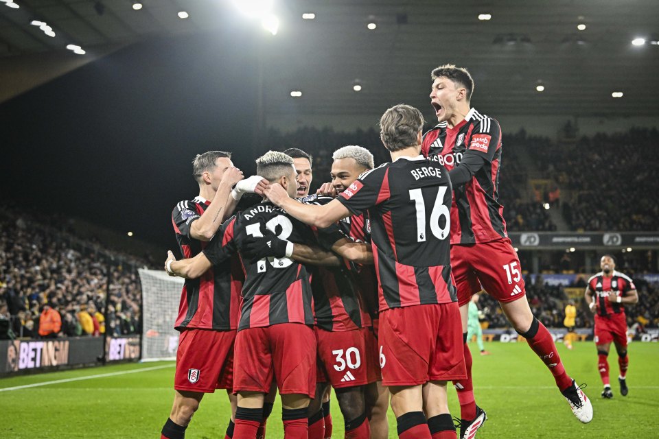 Fulham players celebrating a goal at Molineux Stadium.