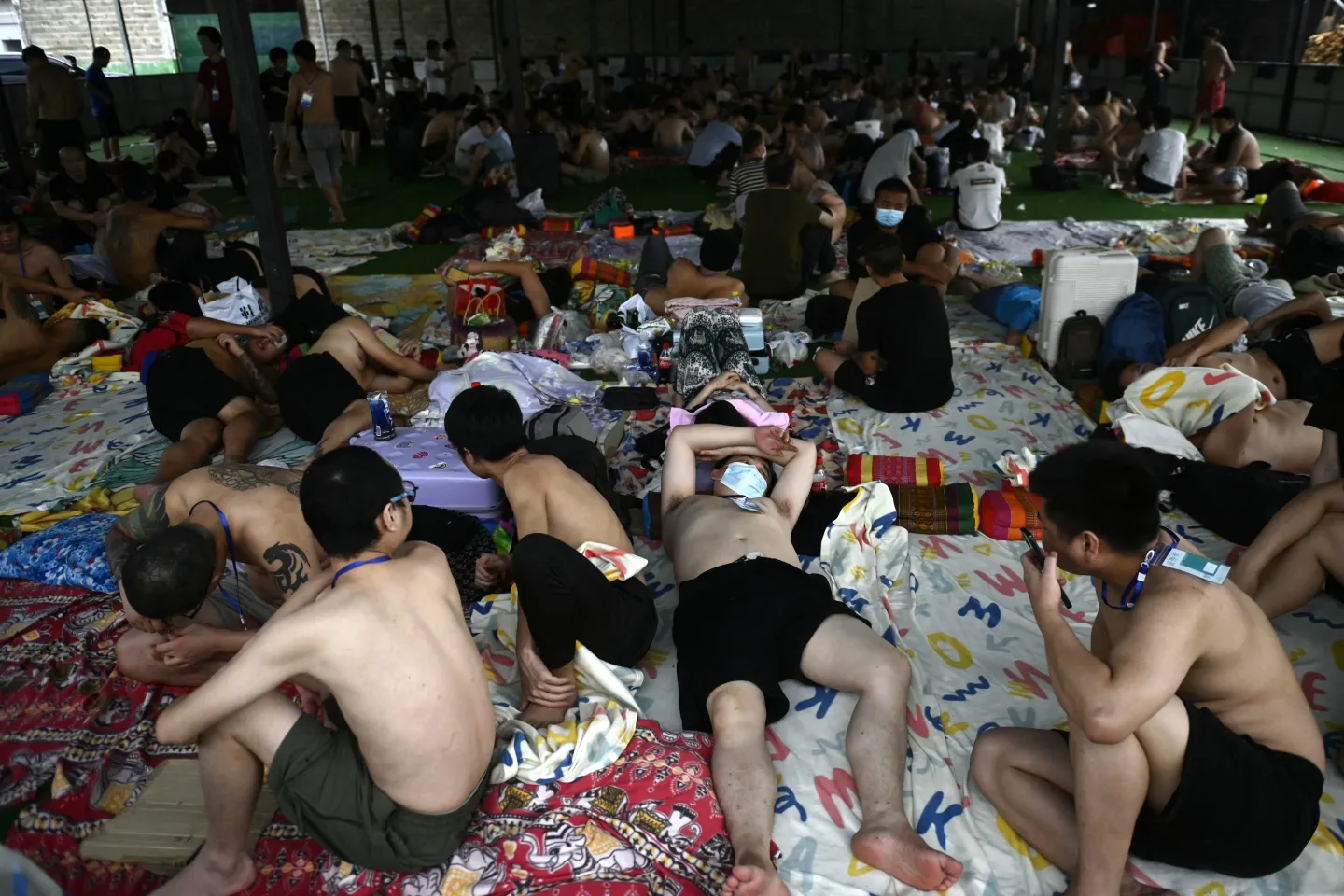 Alleged scam center workers and victims rest during a crackdown operation by the Karen Border Guard Force (BGF) on illicit activity, at the border checkpoint with Thailand in Myanmar's eastern Myawaddy township, on Feb. 23, 2025.