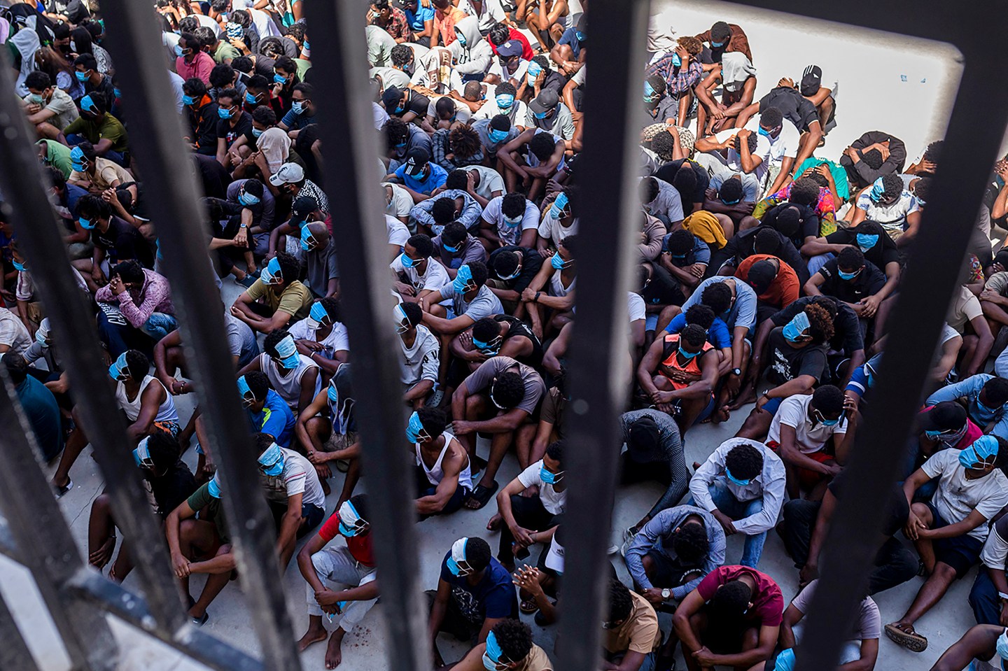 Alleged scam center workers and victims sit on the ground during a crackdown operation by the Karen Border Guard Force (BGF) on illicit activity at the KK Park complex in Myanmar's eastern Myawaddy township on February 26, 2025.