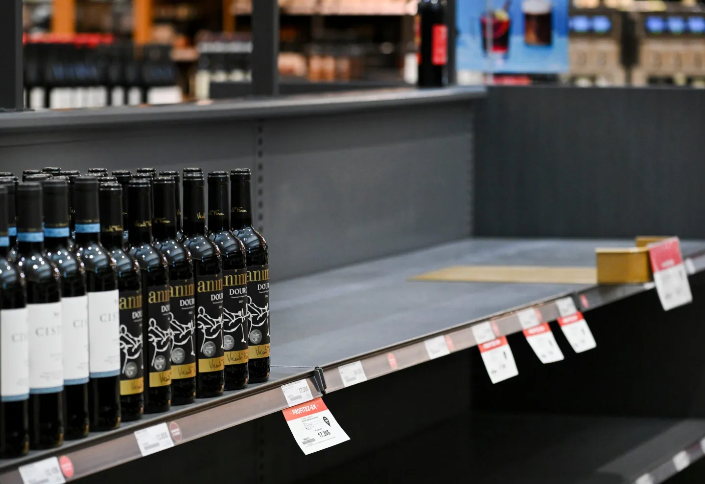 A wine shelf is half-empty