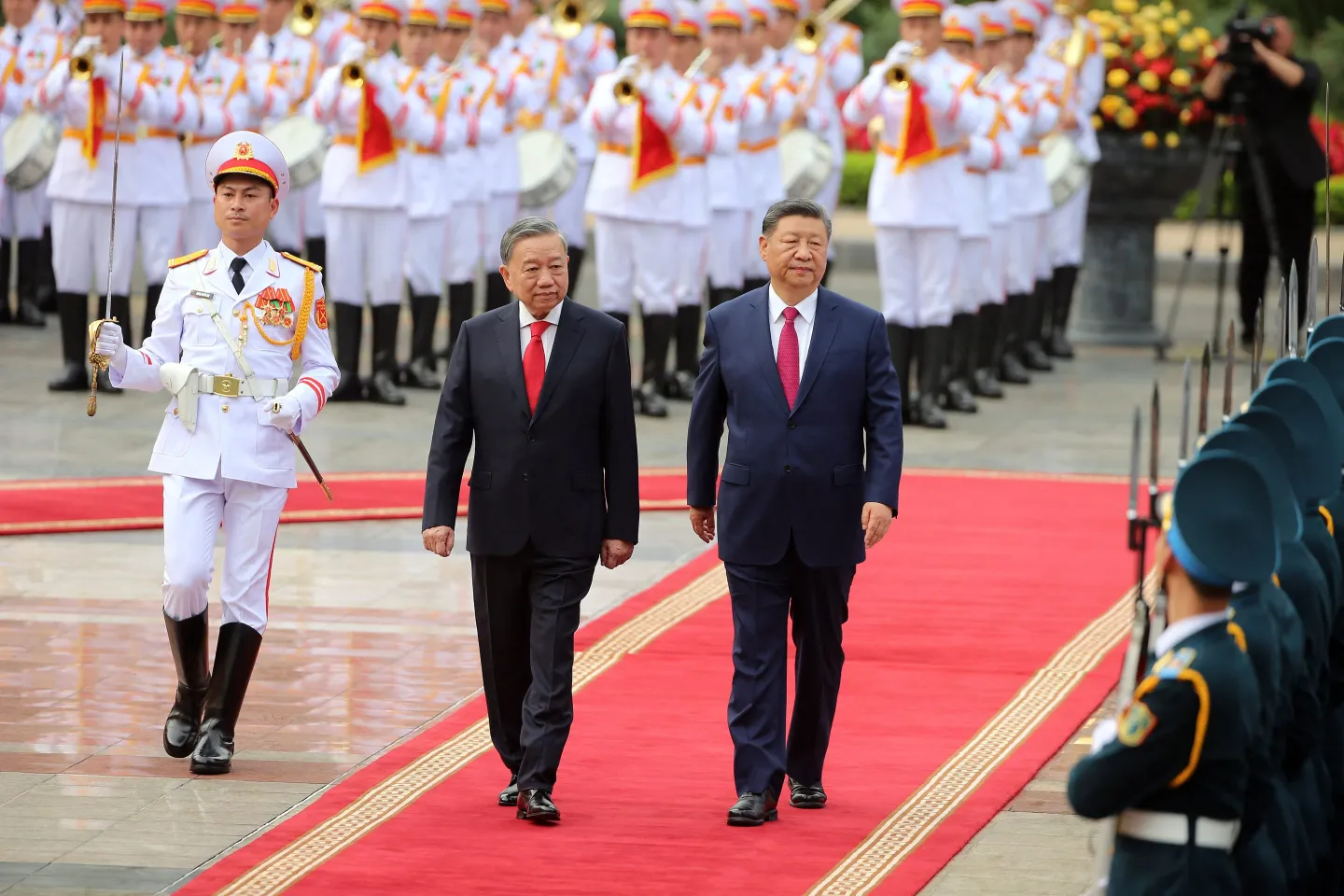 Vietnam's General Secretary of the Communist Party To Lam (center) and Chinese President Xi Jinping (right) review the guard of honor during a ceremonial welcome at the Presidential Palace in Hanoi on April 14, 2025.