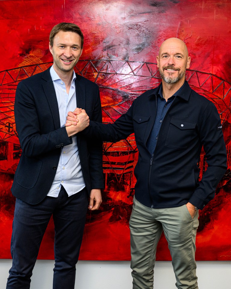 Photo of two men shaking hands in front of a red painting.