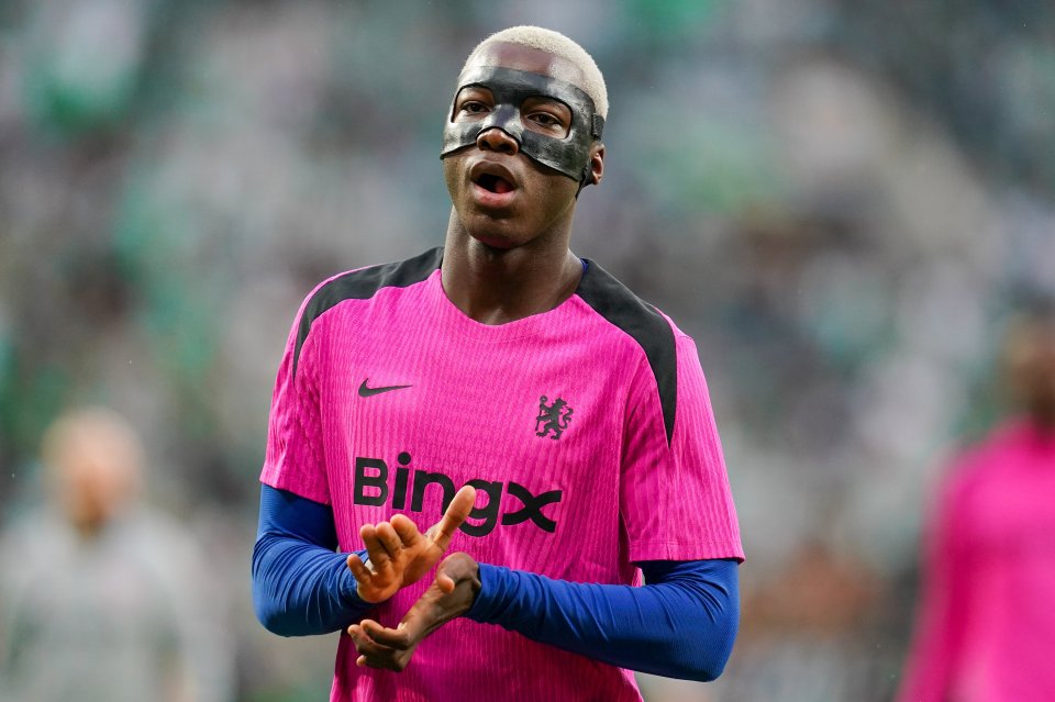 Moisés Caicedo, Chelsea FC midfielder, wearing a protective face mask, applauds fans.