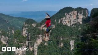 Competitors walk slackline 400m above Chinese gorge