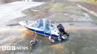 Four men rescued from boat teetering on dam edge
